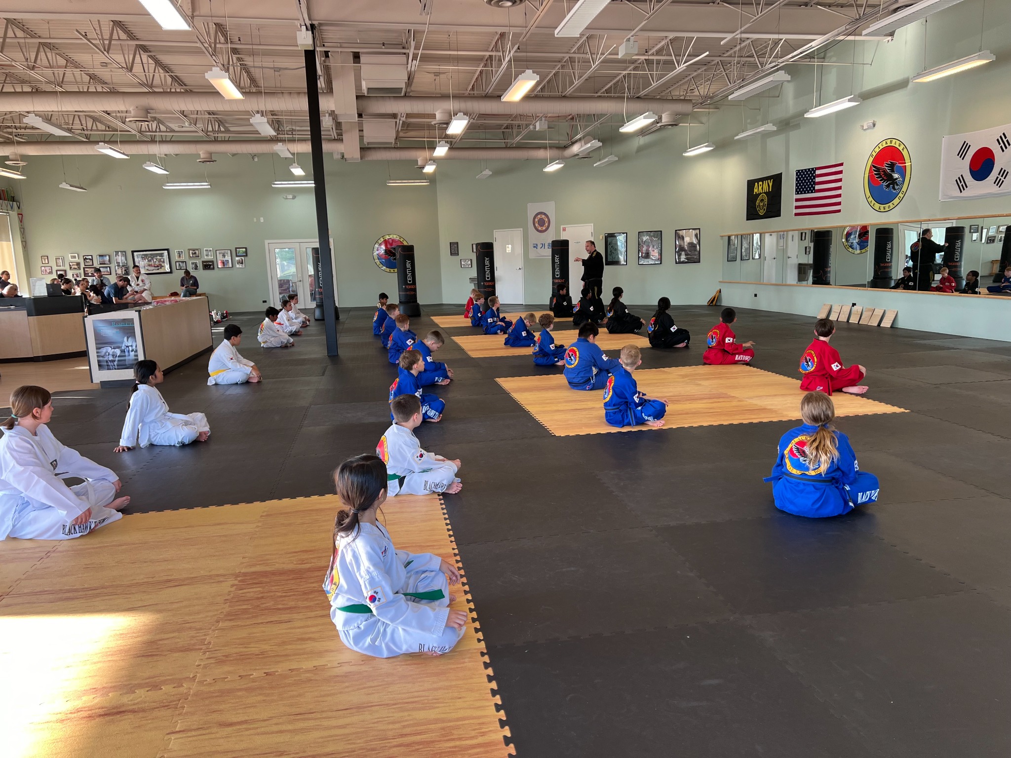 Students seated on training mats during a TaeKwonDo class at Blackhawk in Carpentersville