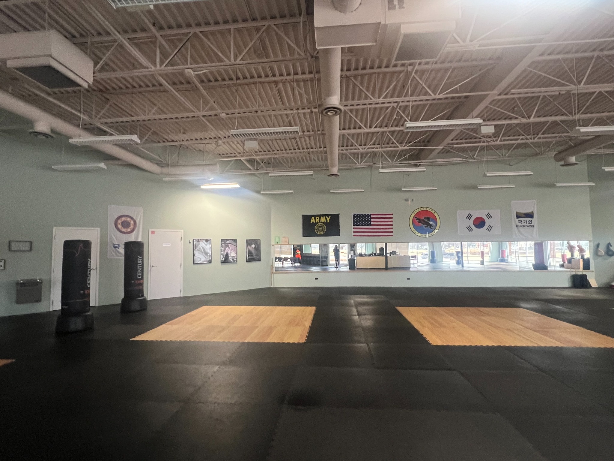 Blackhawk TaeKwonDo training space with interlocking mats, mirrors and freestanding punching bags